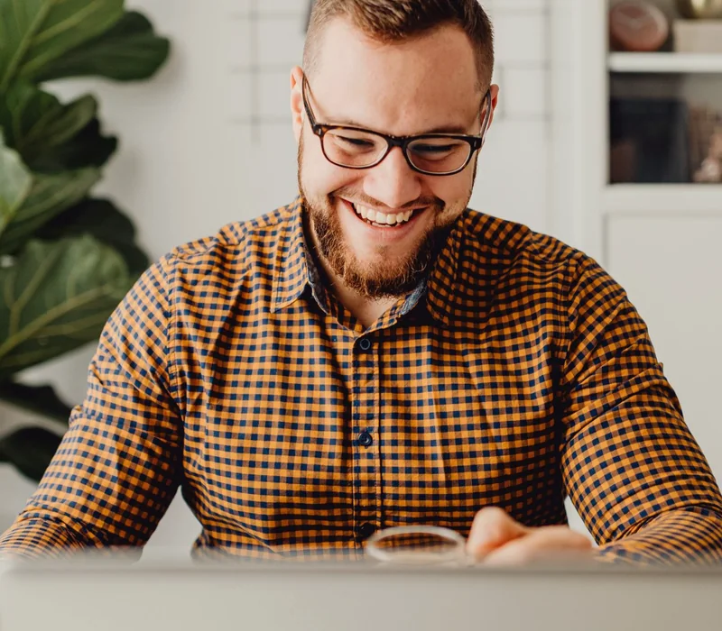 Marketing lead smiling at his laptop