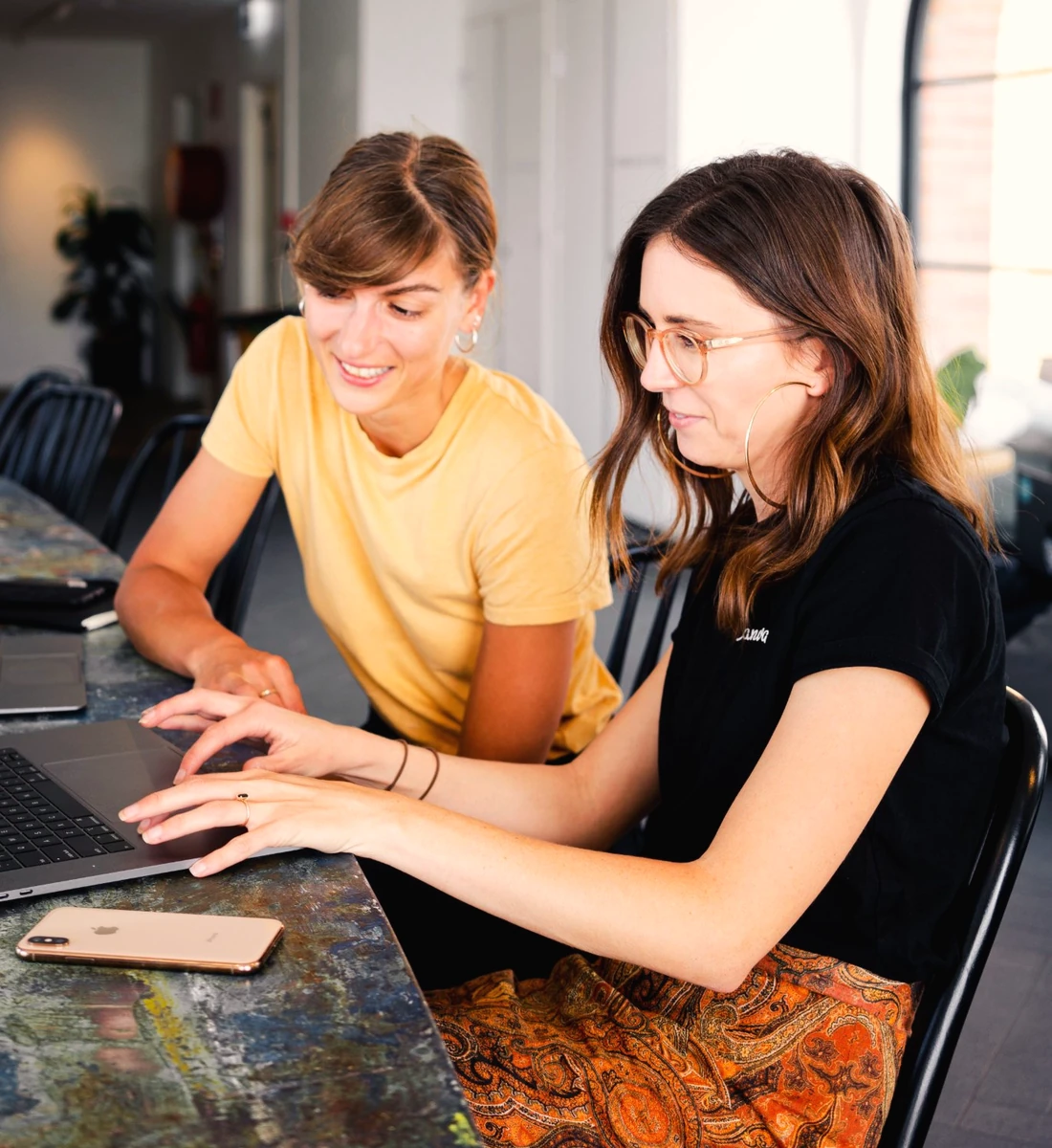 Two colleagues working through something together at a laptop